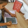 Fille dessinant une princesse sur tablette à dessin Kidydram-mini violette.