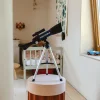 Télescope astronomique Kidytélescope bleu et noir sur trépied argenté dans chambre enfant