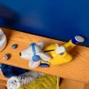 Tirelire chien Puce et Pilou allongé jaune, casque bleu, écouteur rouge