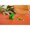 Éléphant vert et jaune en briques Plus-Plus, pièces supplémentaires à côté, fond orange.