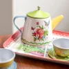 Théière en métal blanc fleurie, couvercle vert, bec jaune, poignée bleue, plateau décoré Moulin Roty.